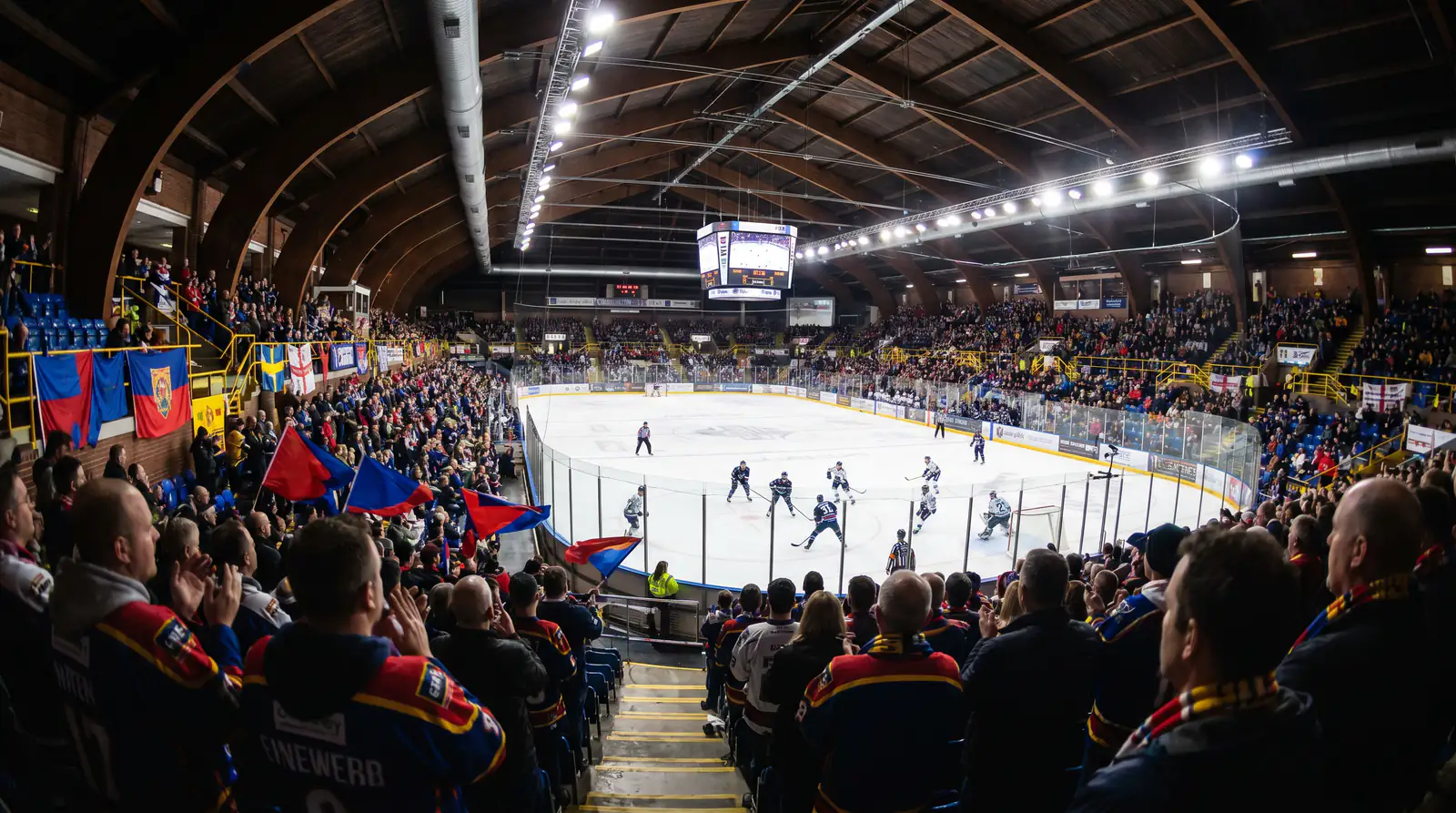 British ice hockey arena during an EIHL match with fans in team colours and banners