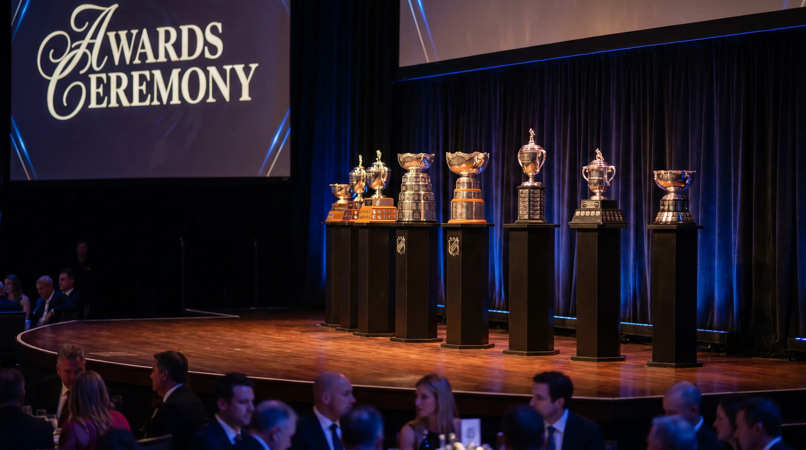 NHL awards ceremony stage with individual trophies displayed under spotlights