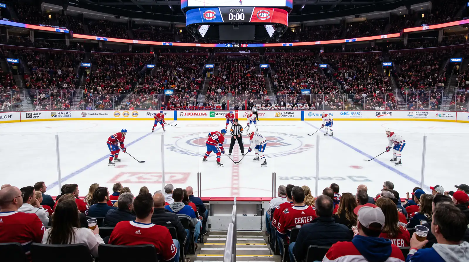 NHL game action during the first period with players skating through the neutral zone