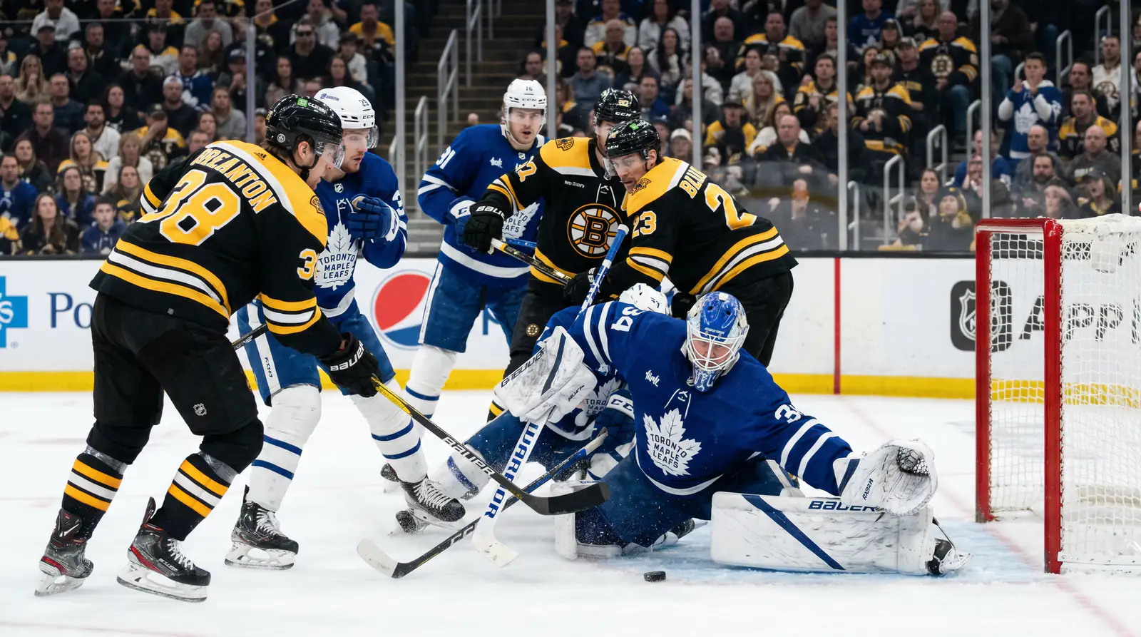 NHL playoff game in overtime with players battling intensely in front of the net